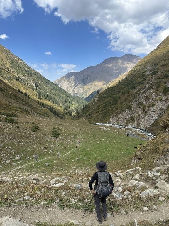 Hiker looking down a green valley