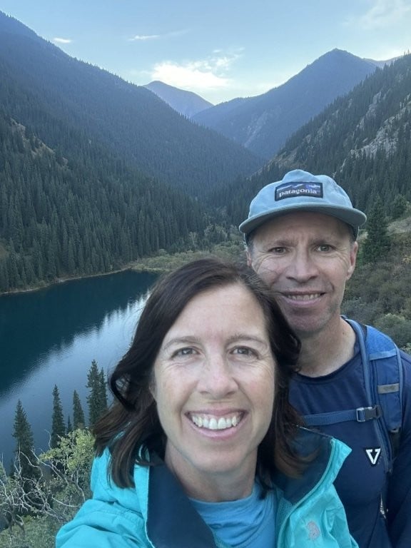 Couple selfie in front of a lake surrounded by forest